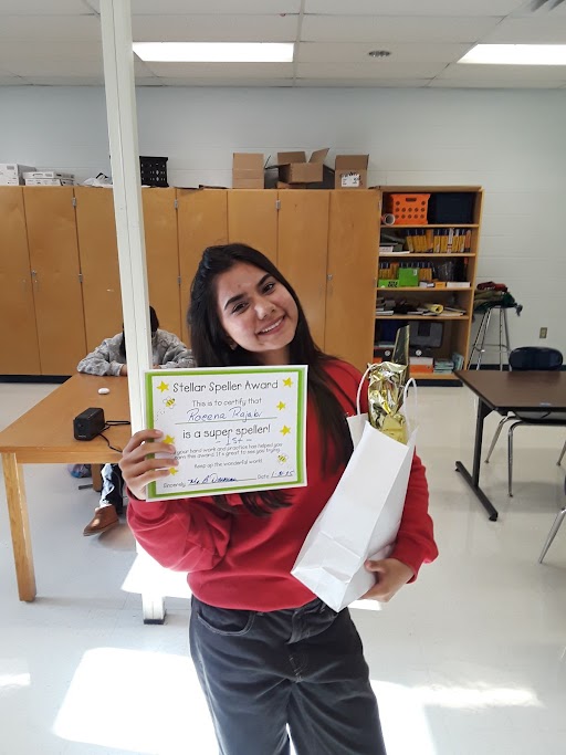 A student posing with an award