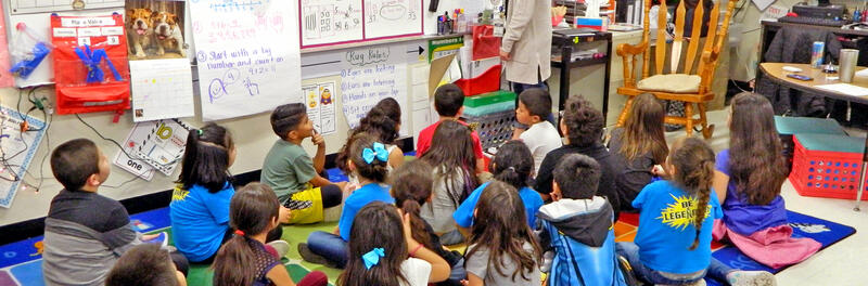 Students sitting on carpet learning lesson