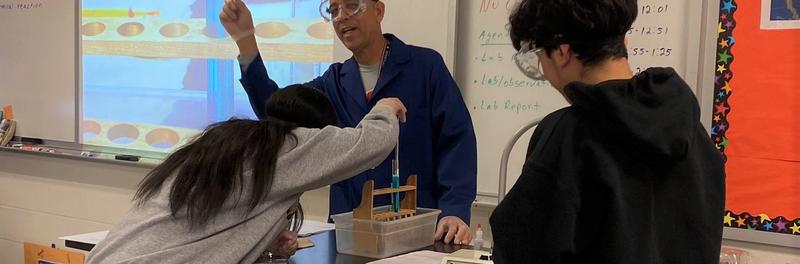 Students conducting science experiment with science Teacher Mr. Ortiz