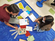 Students participating in a STEM activity on the classroom floor.