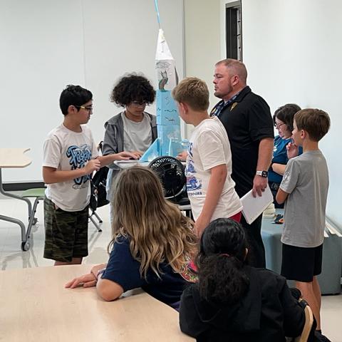 6th grade science students test their wind-resistant structures.