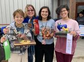 Teacher and three students holding winning sculpture pieces