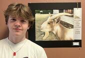 Student next to winning painting of a goat